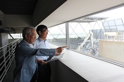 東京工場を見学する、株式会社リーテム取締役会長の中島賢一さん（左）と、一般財団法人環境イノベーション情報機構理事長の大塚柳太郎（右）。