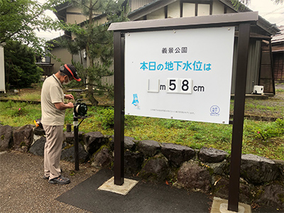 市民の手計で掲示される「本日の地下水位」の看板